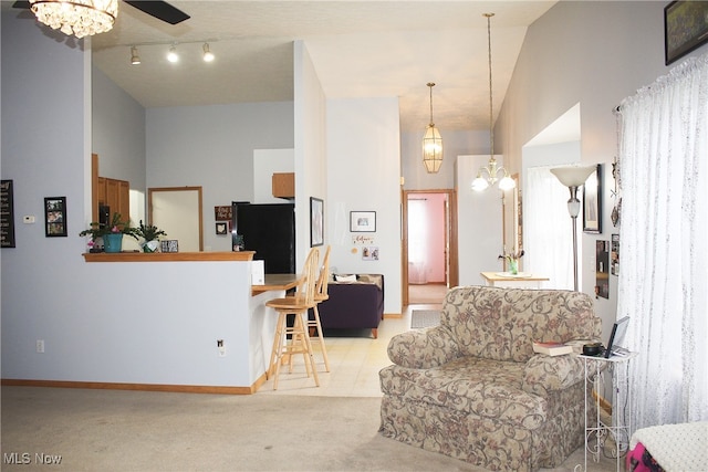 carpeted living room with ceiling fan and high vaulted ceiling