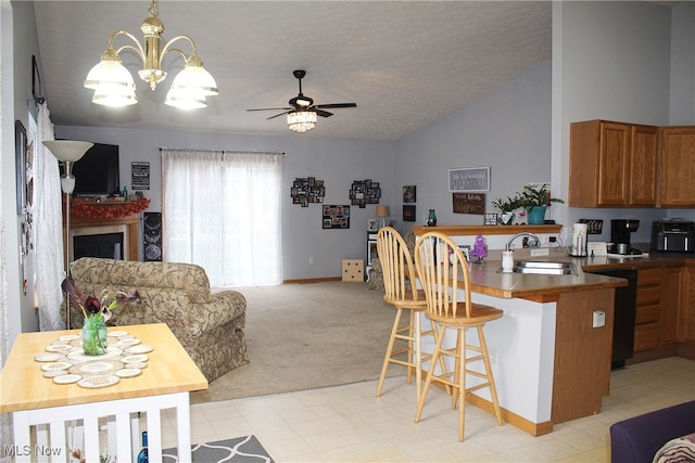 kitchen featuring kitchen peninsula, a kitchen breakfast bar, light colored carpet, vaulted ceiling, and sink