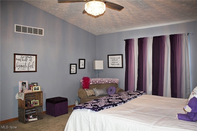 carpeted bedroom with a textured ceiling and ceiling fan