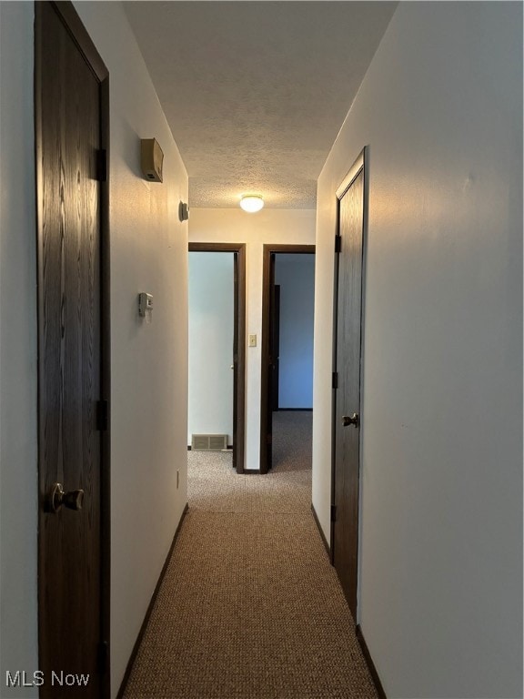 hall with light colored carpet