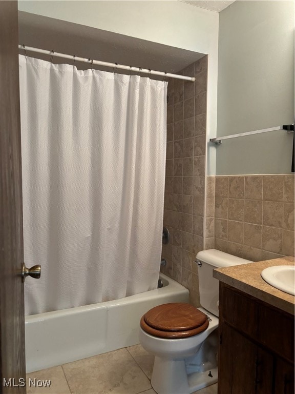 bathroom featuring tile patterned floors, vanity, toilet, and tile walls