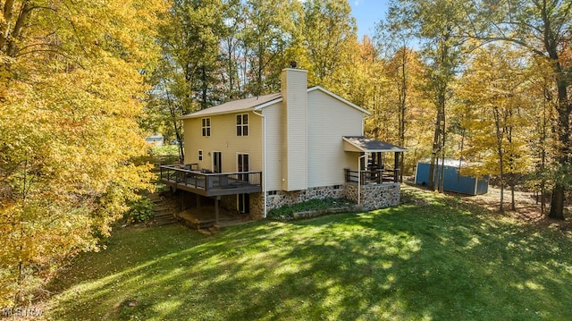 rear view of property with a storage shed, a deck, and a yard