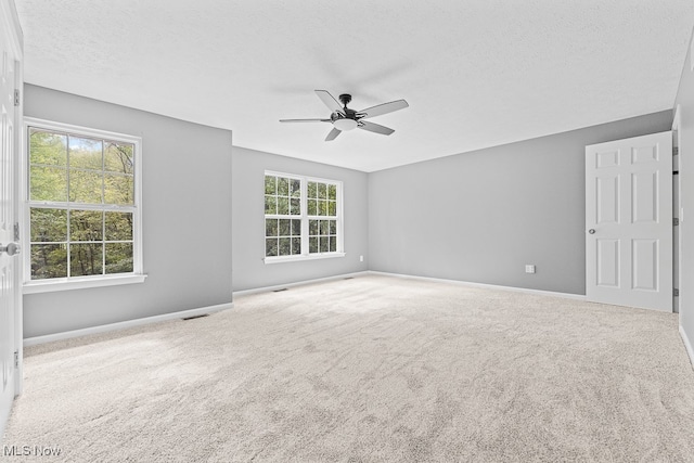 unfurnished room featuring carpet flooring, ceiling fan, and a textured ceiling