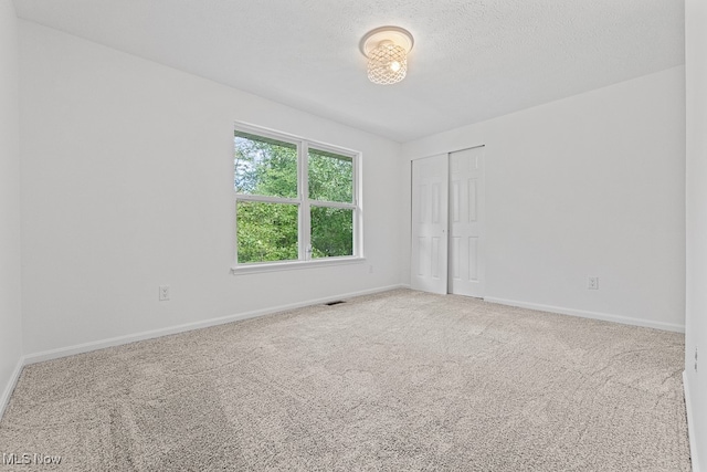 unfurnished room featuring carpet floors and a textured ceiling