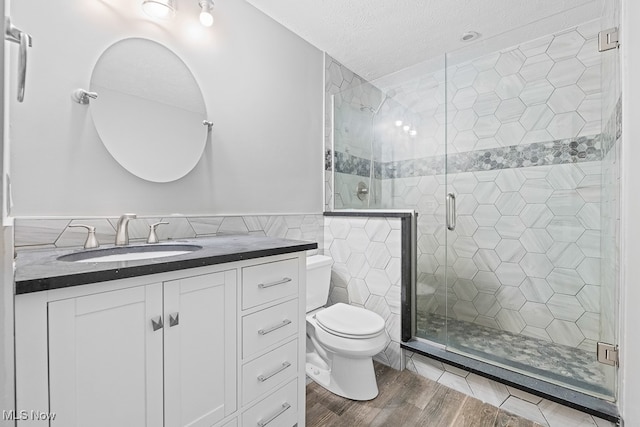 bathroom with hardwood / wood-style floors, toilet, tile walls, and walk in shower