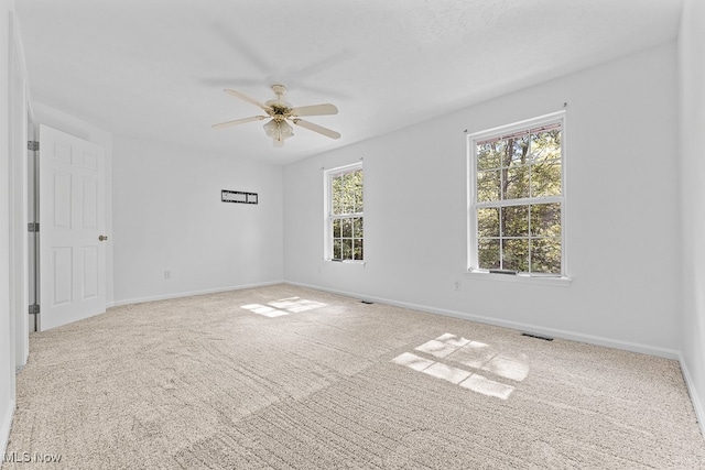 carpeted spare room featuring ceiling fan