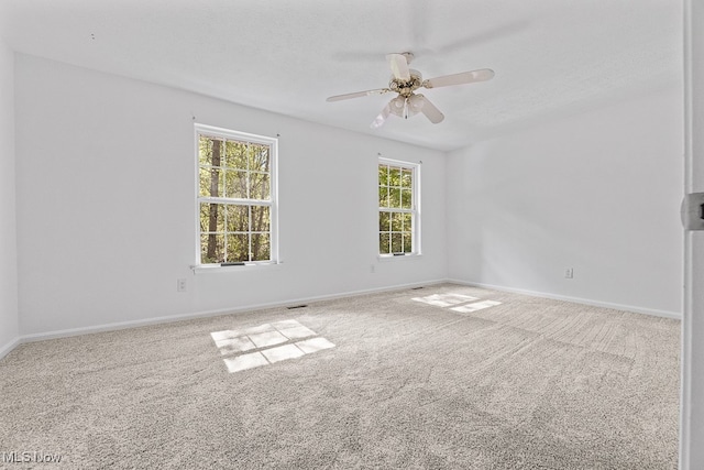 unfurnished room featuring a wealth of natural light, carpet floors, and ceiling fan