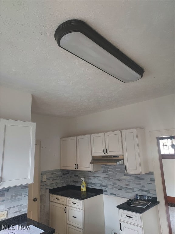 kitchen featuring tasteful backsplash, white cabinetry, and a textured ceiling