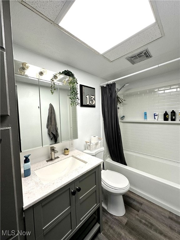 full bathroom featuring hardwood / wood-style floors, vanity, toilet, and shower / bath combo with shower curtain