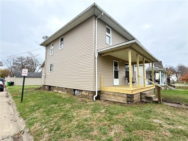 view of side of property with a lawn and covered porch