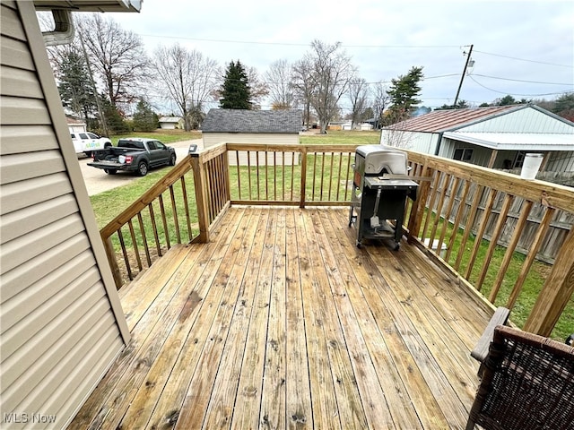 wooden terrace with a grill and a yard