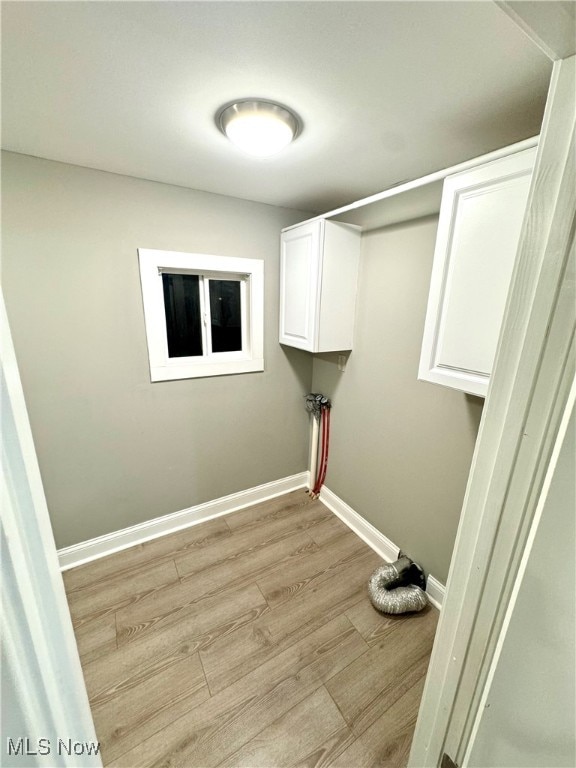 laundry room with cabinets and light hardwood / wood-style floors