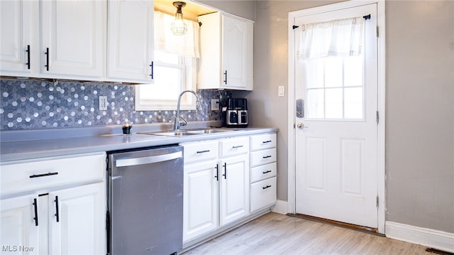 kitchen featuring decorative backsplash, white cabinets, sink, dishwasher, and light hardwood / wood-style floors