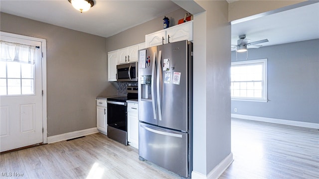 kitchen featuring white cabinets, ceiling fan, light wood-type flooring, and stainless steel appliances