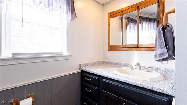 bathroom featuring vanity and wood walls