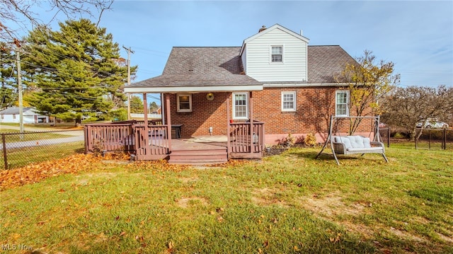 rear view of property featuring a lawn and a deck