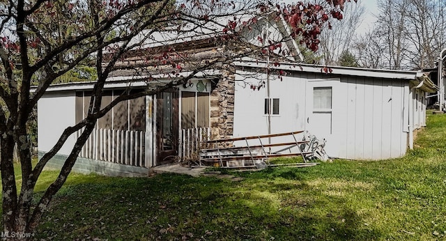 view of outbuilding featuring a sunroom and a yard