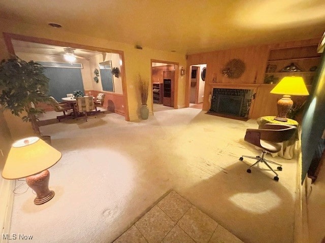 living room featuring carpet, a brick fireplace, and ceiling fan