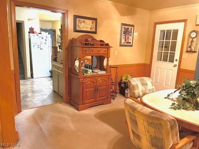 living area with light colored carpet and ornamental molding