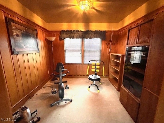 workout area with wood walls and light carpet