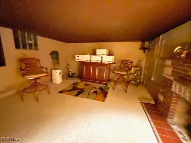 sitting room featuring carpet and a brick fireplace