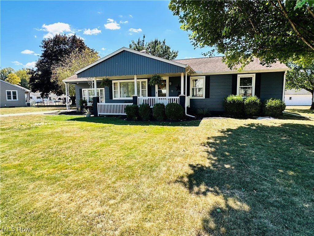 single story home with covered porch and a front lawn