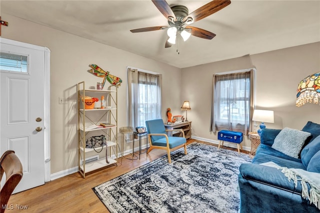 living room featuring ceiling fan, a healthy amount of sunlight, and wood-type flooring