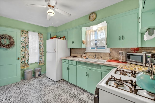 kitchen featuring decorative backsplash, white appliances, ceiling fan, and sink