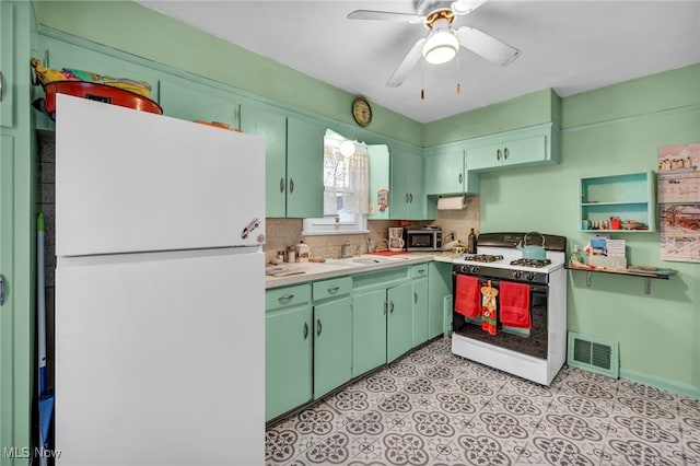 kitchen with decorative backsplash, white appliances, ceiling fan, sink, and green cabinets