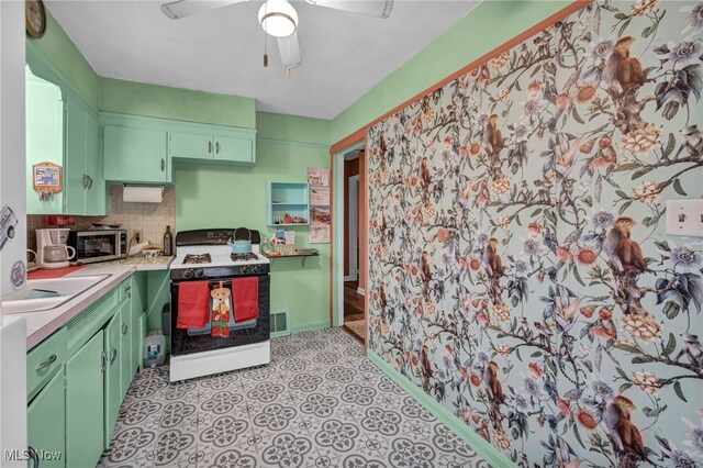 kitchen with decorative backsplash, green cabinets, gas range gas stove, and ceiling fan