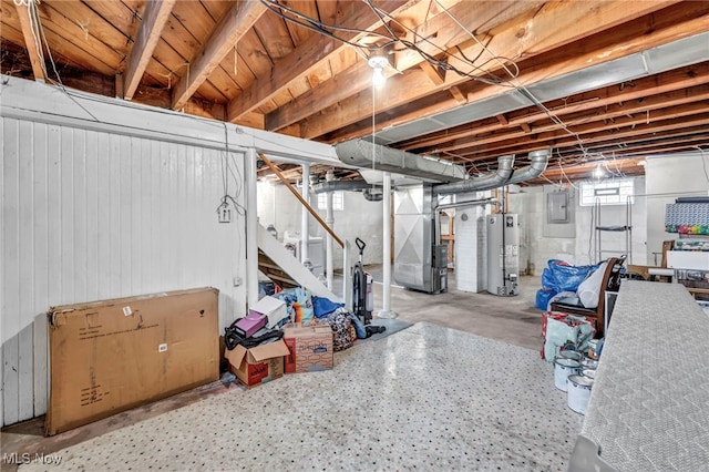 basement with electric panel, heating unit, and water heater