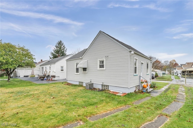 view of side of home featuring a lawn, a patio area, and central air condition unit