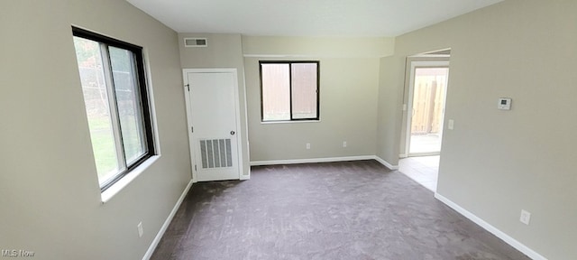 carpeted spare room featuring a healthy amount of sunlight