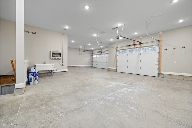 garage featuring heating unit, a garage door opener, and sink