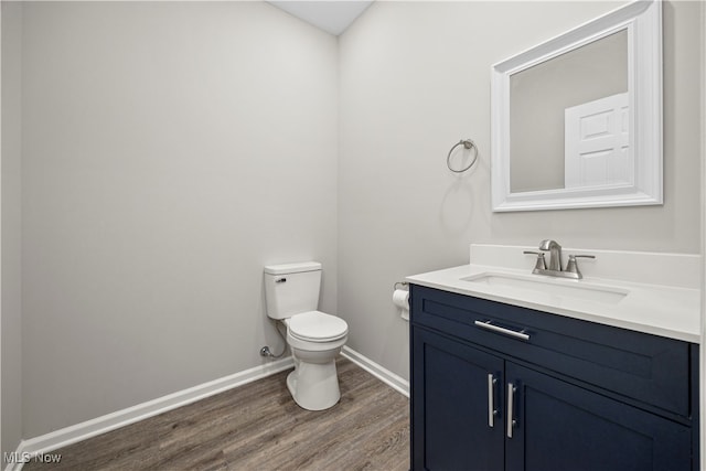 bathroom with vanity, toilet, and wood-type flooring