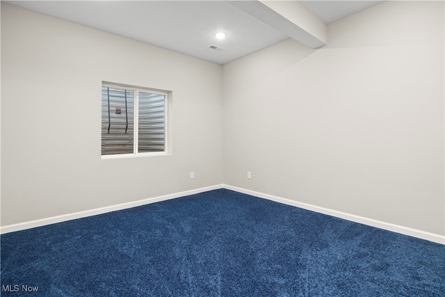 unfurnished room with beam ceiling and carpet floors