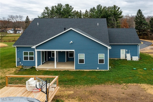 rear view of house featuring a lawn and a deck