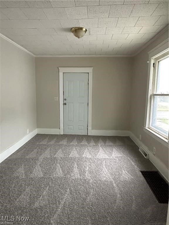 carpeted empty room featuring crown molding