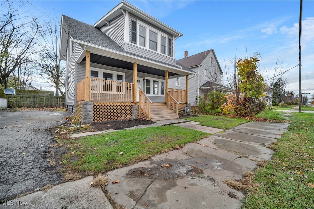 view of front of house with covered porch and a front lawn