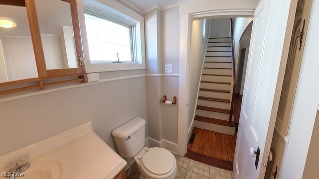 bathroom with vanity, toilet, and crown molding