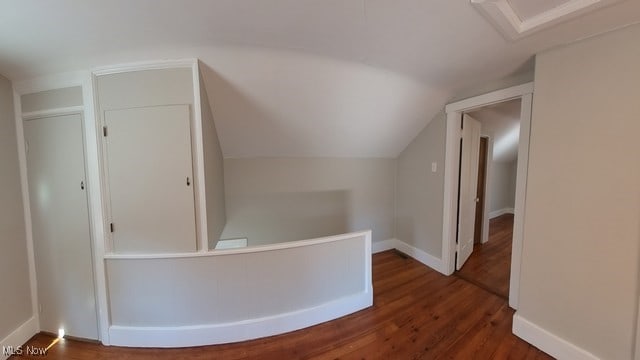 hall featuring lofted ceiling and dark wood-type flooring