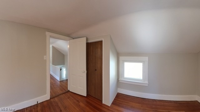 bonus room with hardwood / wood-style floors and vaulted ceiling