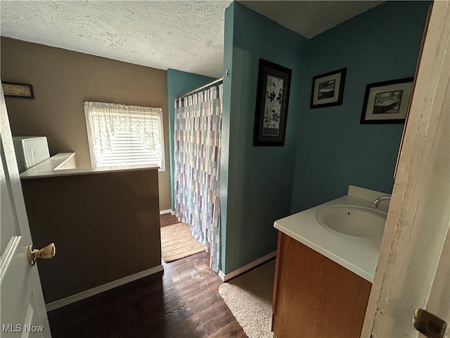 bathroom with hardwood / wood-style flooring, vanity, and a textured ceiling