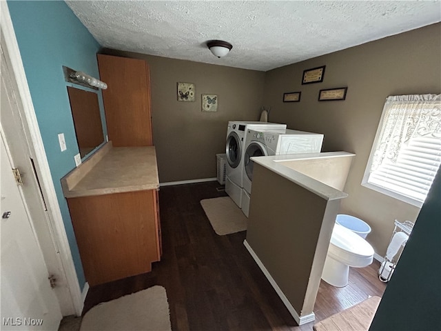 washroom featuring dark hardwood / wood-style floors, washing machine and dryer, and a textured ceiling