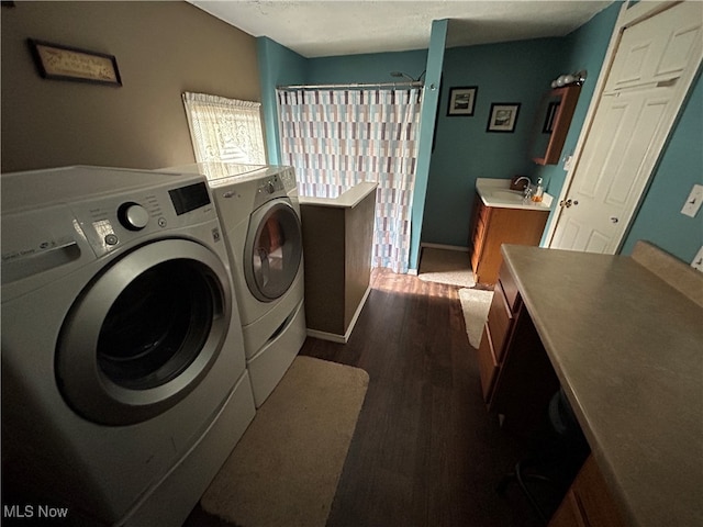 laundry area with hardwood / wood-style floors, separate washer and dryer, and sink