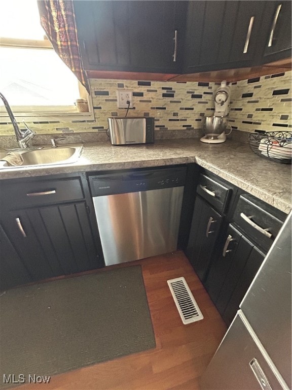 kitchen with backsplash, stainless steel dishwasher, dark wood-type flooring, and sink