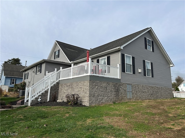 view of side of home featuring a yard and central air condition unit