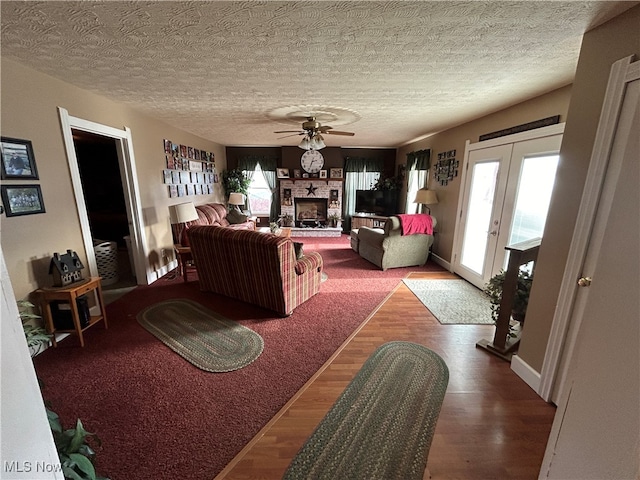 living room with french doors, wood-type flooring, a textured ceiling, and ceiling fan