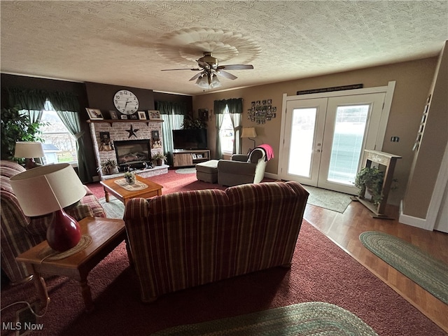 living room with hardwood / wood-style floors, plenty of natural light, a fireplace, and french doors