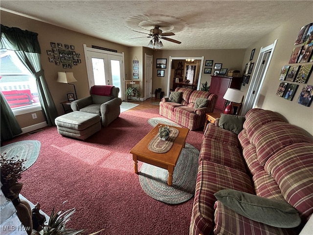 carpeted living room with ceiling fan, french doors, and a textured ceiling